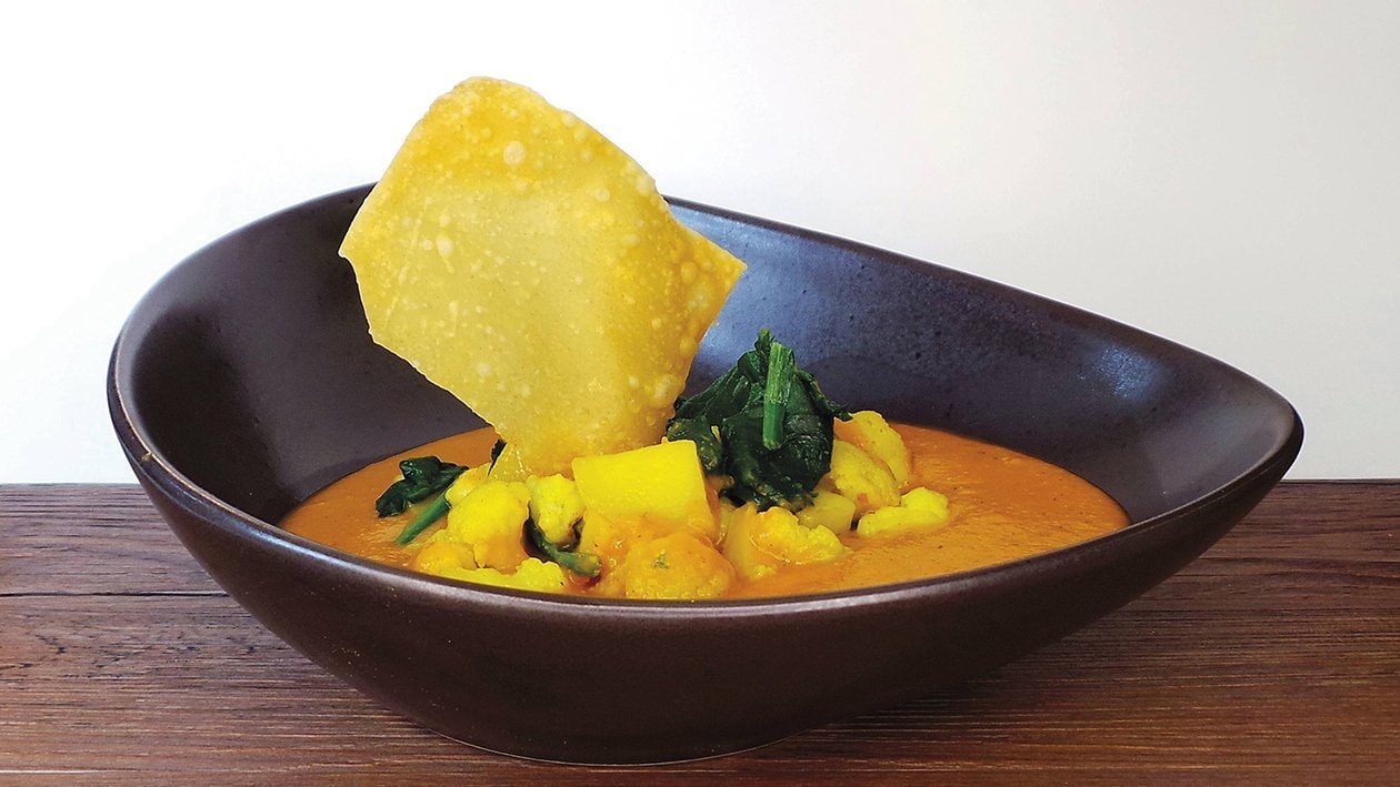 Dal von roten Linsen mit Curry-Blumenkohl, Kartoffeln und Spinat dazu gebackene Wan Tan –  