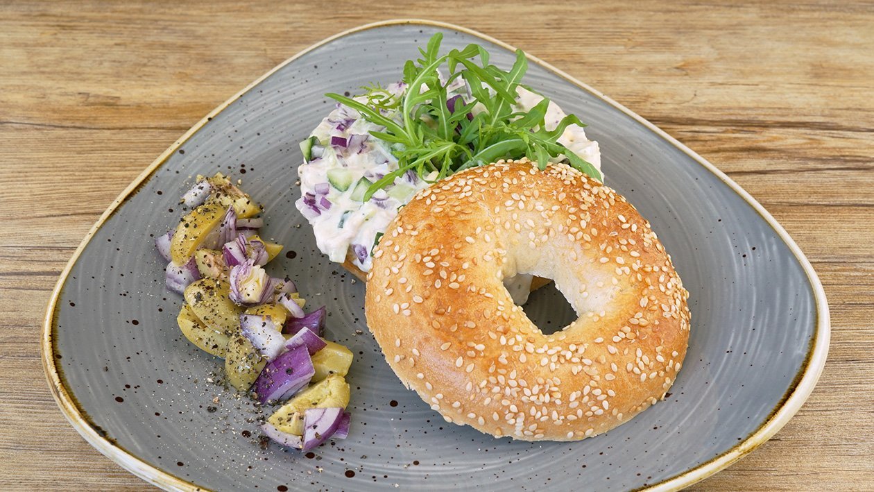 Bagel mit Thunfisch, Ei, Salatgurke und Oliven –  