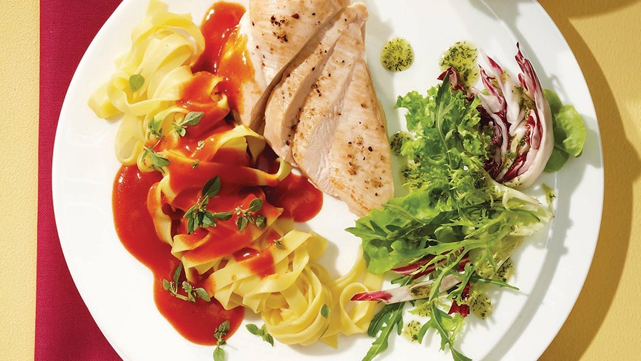 Hähnchenbrustfilet in Tomatensauce auf Bandnudeln mit gemischten Blattsalaten