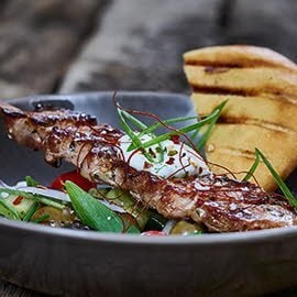 Schweinesouvlaki im Pitabrot mit Tzaziki und griechischem Salat Schweinesouvlaki im Pitabrot mit Tzaziki und griechischem Salat