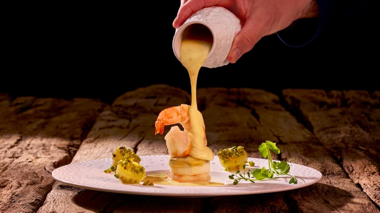 Gebratene Wildgarnele, Erdnussbutter-Bearnaise, geflämmter Kohlrabi mit Stiltonkäse und Pistazien Kartoffeln –  