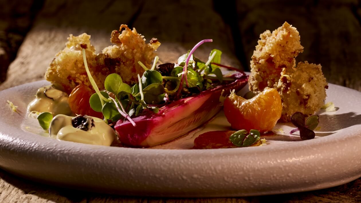 Wildgarnele in Brezenflocken, Kaffirlimetten-Cranberry Hollandaise, Mandarinen Chicorée und Floraler Garten in Balsamico Vinaigrette –  