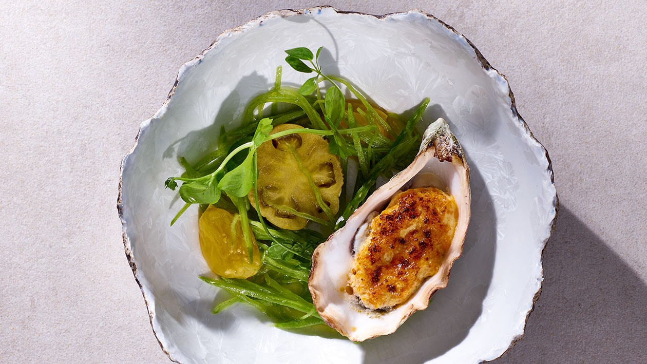 Gratinierte Felsenauster mit Shichimi-Hollandaise und kleinen Salat von gerösteten Tomatillo und Erbsen –  