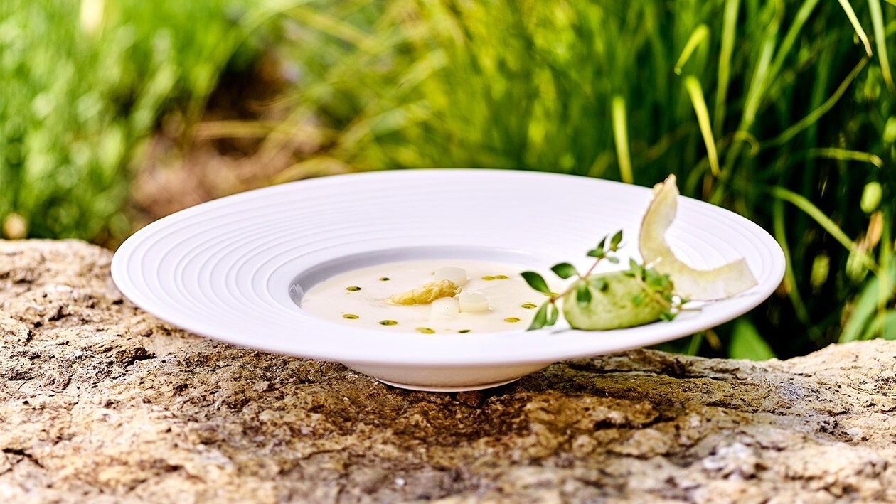 Spargel-Kokos-Suppe mit Auflauf von jungen Erbsen.
