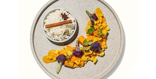 Gelbes Pflanzencurry mit pinkem Blütenkohl und würzigem Jeerareis