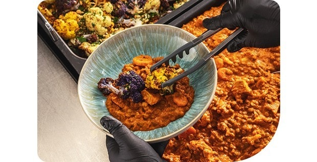 Scheibe vom gegrillten Blumenkohlkopf mit Madras Curry abgeschmeckten Linsen Dal