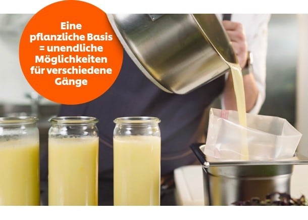 Ein Koch gießt eine Soße in ein Gefäß Ein Koch gießt eine Soße in ein Gefäß